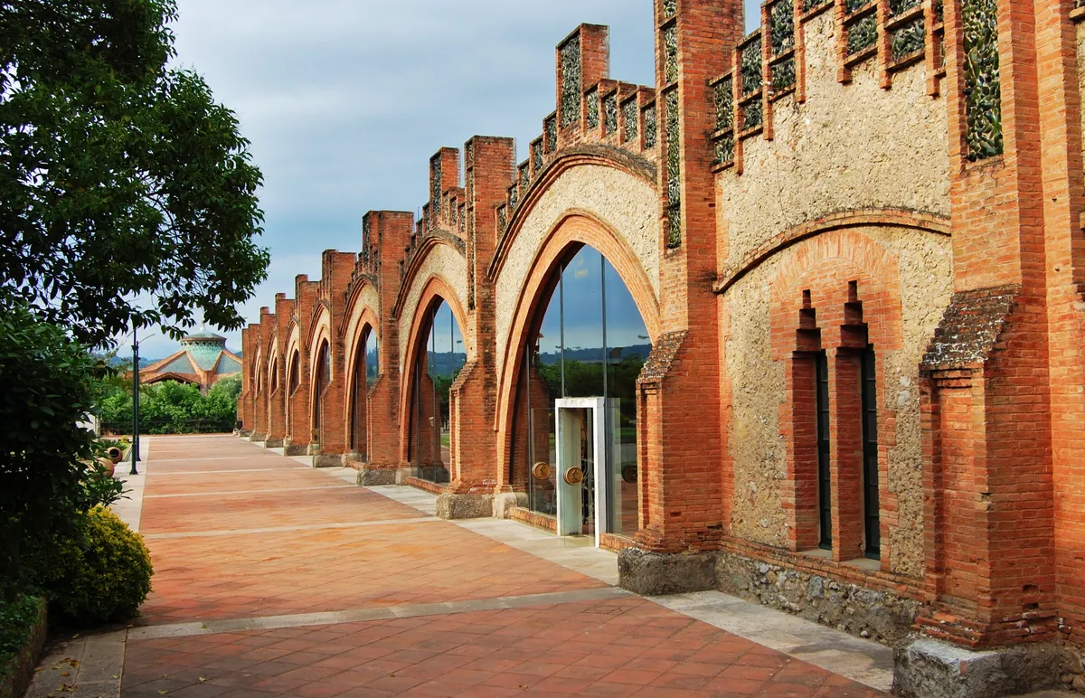 Fachada exterior de las Caves Codorníu en Sant Sadurní d'Anoia, edificio modernista de ladrillo visto con arcos parabólicos y trencadís