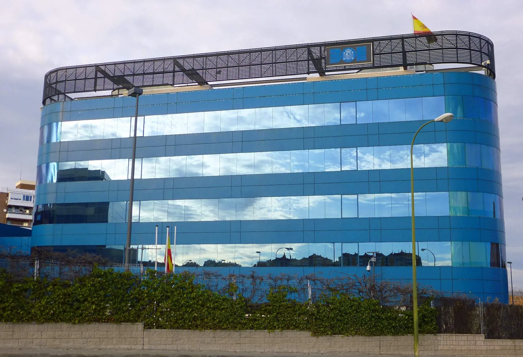 Sede del Boletín Oficial del Estado en Madrid, edificio acristalado azulado con escudo institucional