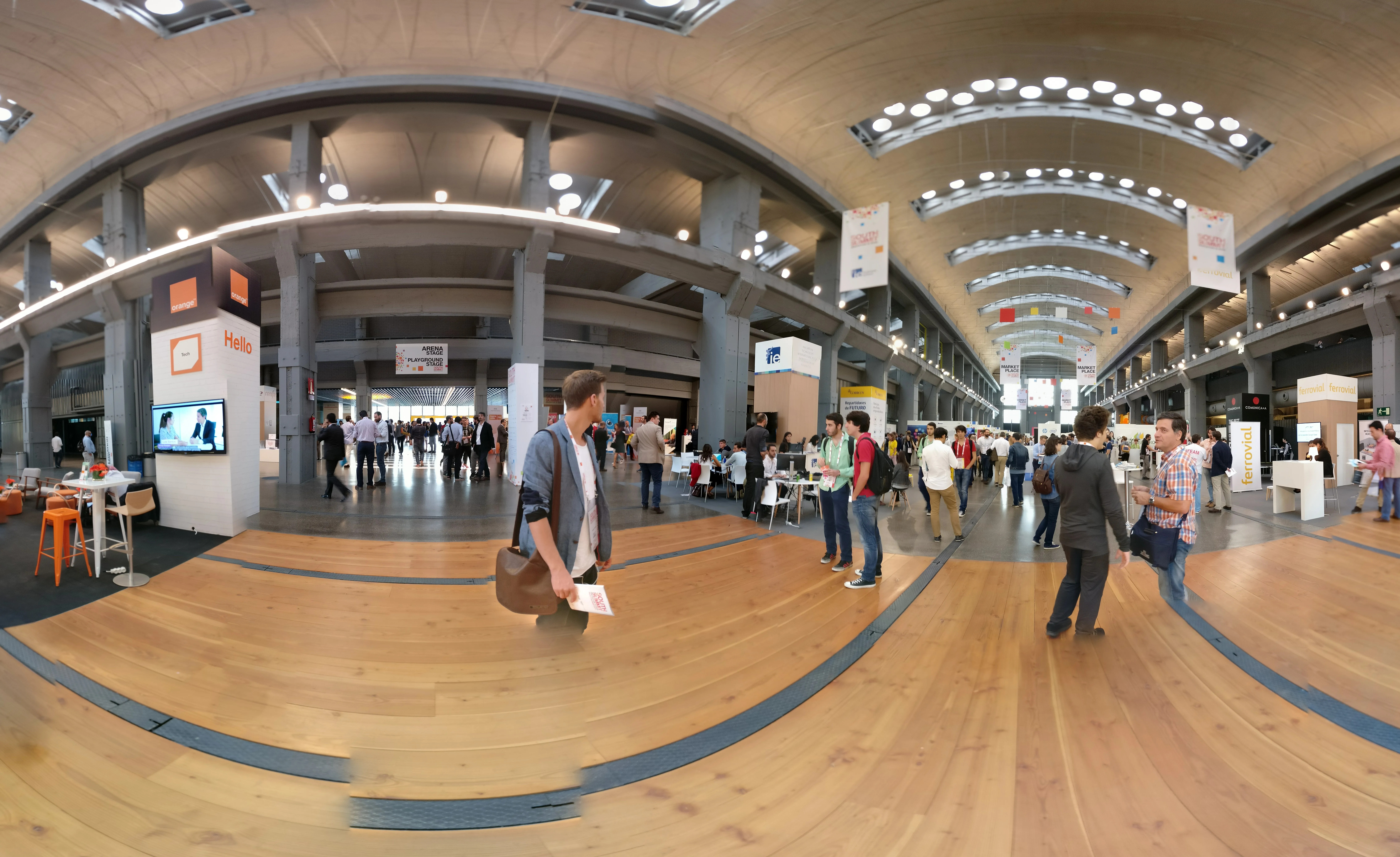 Vista panorámica del hall principal de South Summit 2016 en La Nave (Madrid), con stands, asistentes y techo abovedado de hormigón