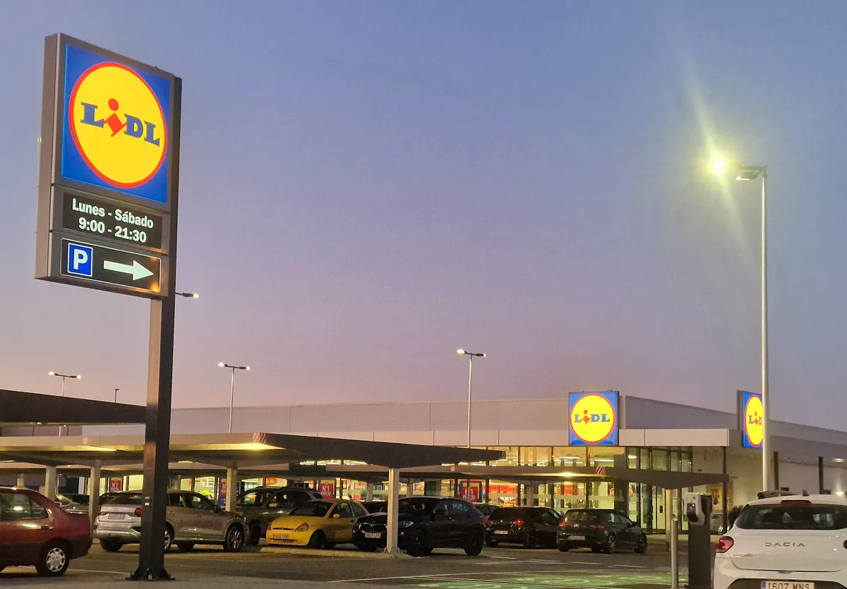 Tienda Lidl al anochecer en Chauchina (Granada), con aparcamiento iluminado, tótem azul y amarillo de la cadena en primer plano y rótulos sobre la entrada