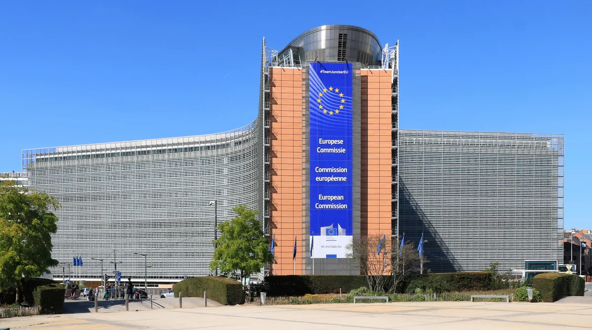 Edificio Berlaymont en Bruselas, sede de la Comisión Europea, con bandera de la UE y rótulo trilingüe en la fachada
