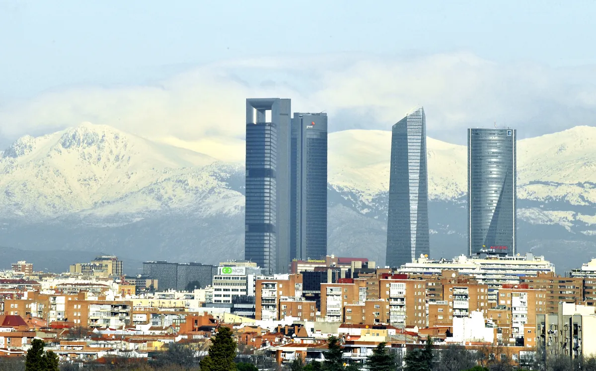 Skyline de las Cuatro Torres de Madrid sobre la sierra de Guadarrama nevada al fondo