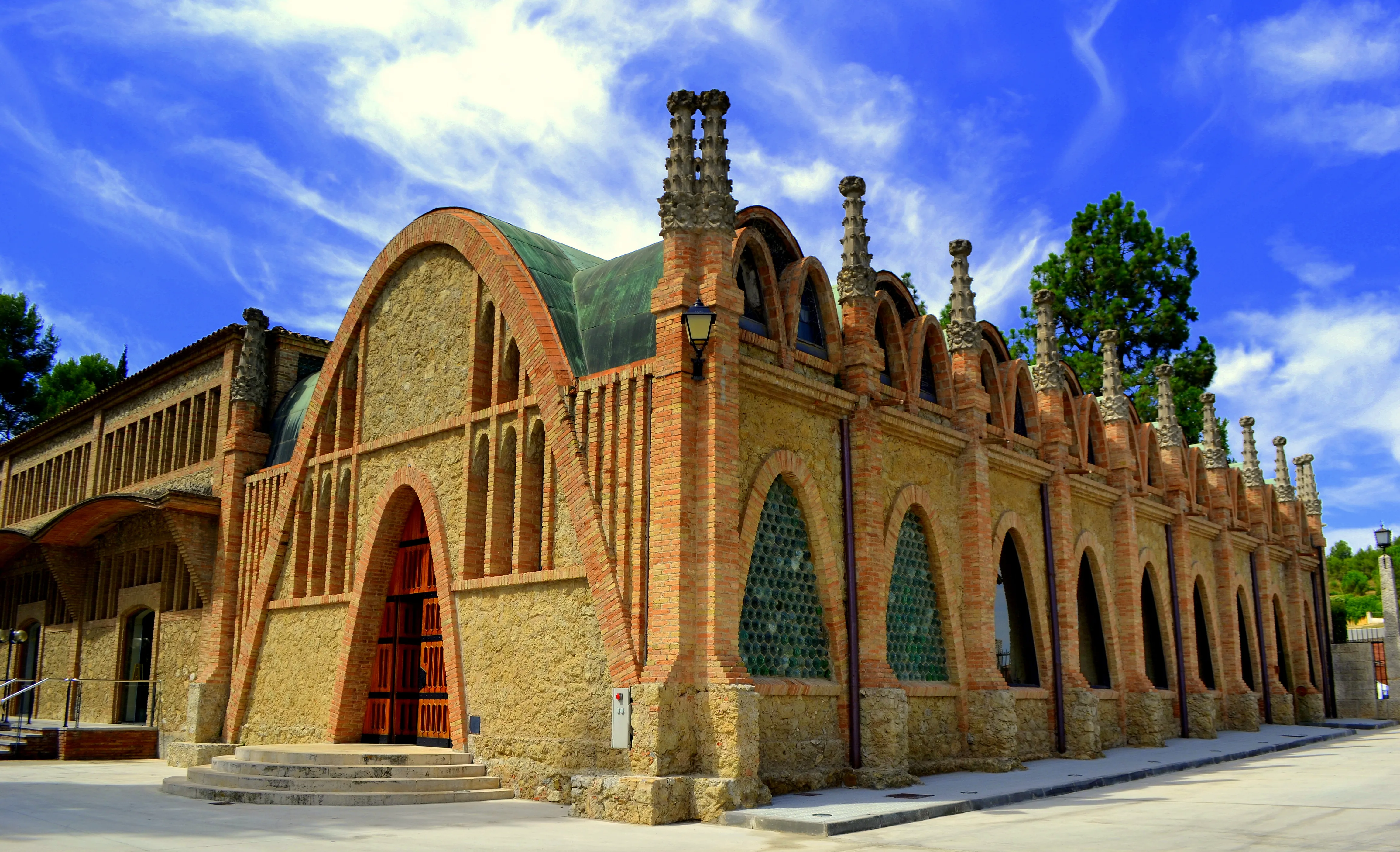 Cavas Codorníu en Sant Sadurní d'Anoia: nave modernista de Puig i Cadafalch con arco parabólico de ladrillo y trencadís a contraluz